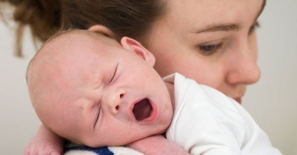 baby rubs face on shoulder