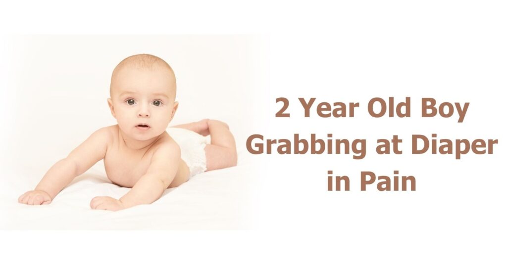 2 year old boy grabbing at diaper in pain