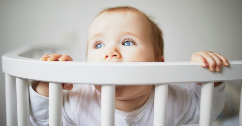 Baby Sleeps With Head Against Crib Bars